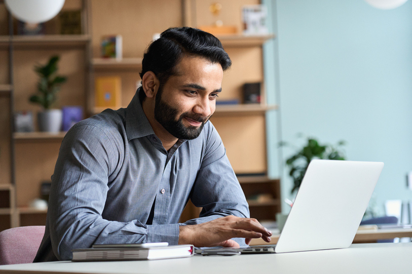 Teacher on laptop working on student homework